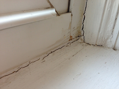 Image of interior window frame corner with broken or cracked seals.