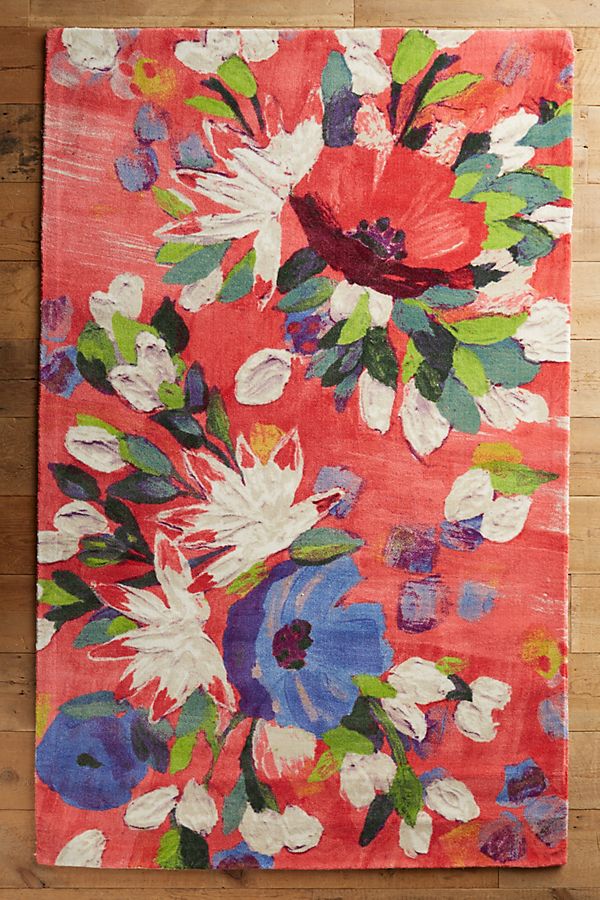 Magnolia coral rug from Anthropologie. The rug is a coral color with large floral print.