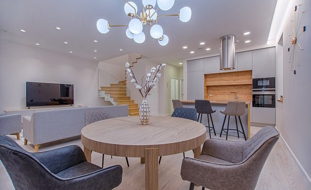 Wood elements in timber construction home. Wood floors, wood table, wood top island, wood backsplash, wood staircase.