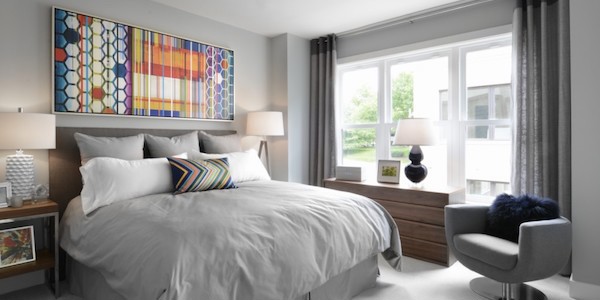 bedroom with modern furniture, artwork, and set of 3 windows