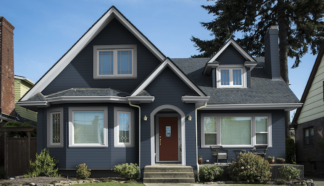 Single family house with navy blue siding, white trim, and a red door